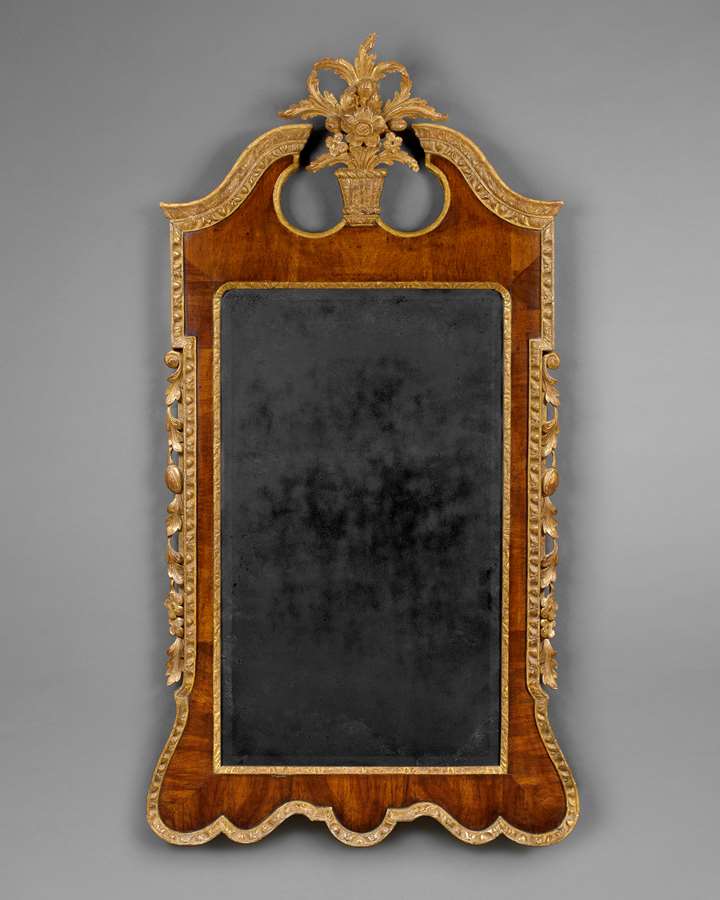 A LARGE GEORGE II PERIOD VENEERED WALNUT AND CARVED GILTWOOD UPRIGHT WALL MIRROR